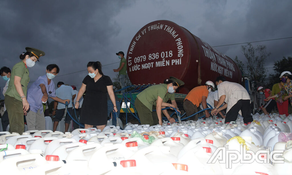Công ty TNHH Cơ khí vận tải Thuận Thành Phong phối hợp hỗ trợ cùng Nữ cán bộ, chiến sĩ Công an tỉnh vận chuyển nước ngọt đến người dân bị ảnh hưởng bởi hạn, mặn ở xã Bình Tân, huyện Gò Công Tây. Ảnh: TRỌNG TÍN